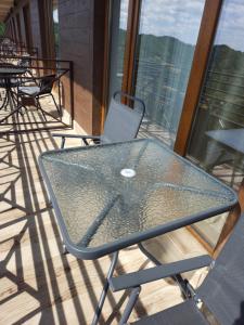 a glass table and chairs on a balcony at Una LUX N85 in Kopaonik +32 photos