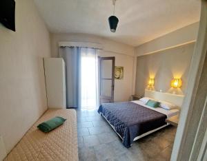 a bedroom with a bed and a large window at Studios Thea Fresh Rooms Thassos in Limenas +166 photos