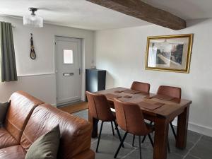 a living room with a wooden table and a couch at Horseshoe Cottage Edwinstowe in Edwinstowe