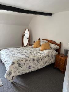 a bedroom with a bed with a mirror on it at Horseshoe Cottage Edwinstowe in Edwinstowe +2 photos