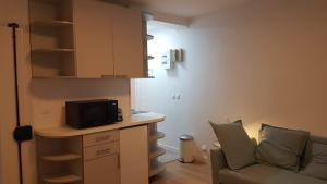 a small living room with a couch and a kitchen at Studio cosy, quartier canal Saint-Martin in Paris +3 photos
