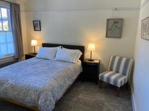 a bedroom with a bed and a chair and two lamps at SF Zen Center Guestrooms in San Francisco