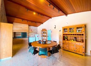a kitchen and dining room with a wooden table and chairs at Rancho Ipê Amarelo - Capitólio - MG in Guapé