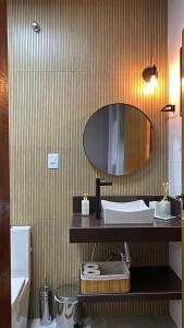 een badkamer met een wastafel en een spiegel bij Pousada Pé da Serra - São Thomé das Letras in São Thomé das Letras