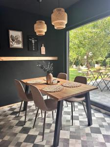ein Esszimmer mit einem Holztisch und Stühlen in der Unterkunft Cuib Glamping in Avrig