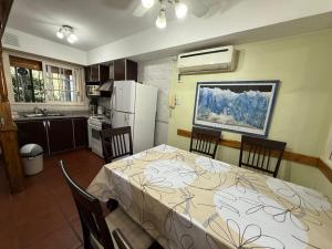a kitchen with a table and chairs and a refrigerator at Chalet Buenos Aires in Buenos Aires