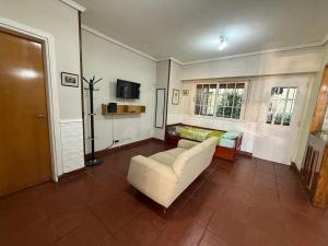 a living room with a couch and a tv at Chalet Buenos Aires in Buenos Aires