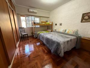 a bedroom with a bed and a wooden floor at Chalet Buenos Aires in Buenos Aires