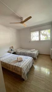 a bedroom with two beds and a ceiling fan at Blue Ocean in Platja  d'Aro