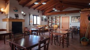 a restaurant with tables and chairs and a fireplace at Agriturismo Costa Verde in Arbus