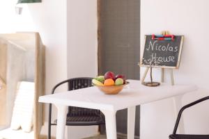 a bowl of fruit on a white table with a chalkboard at Nicola's House in Tsivarás