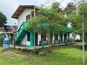 a house with a tree in front of it at Miss Miriam BeachFront Cabins in Tortuguero +90 photos