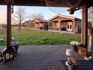 a house with a porch with flowers in a yard at Het baken van Tholen met Wellness en Theetuin in Sint Maartensdijk