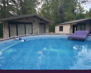 a large blue swimming pool with a purple lounger at Domki Solina Leśny Chillout in Solina
