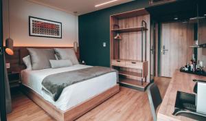 a bedroom with a large bed and a desk at Hotel Sexto by Icono in Armenia