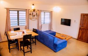 a living room with a blue couch and a table at Résidence comme à la maison in Lomé +4 photos