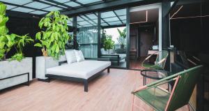 a living room with a white couch and chairs on a balcony at Hotel Sexto by Icono in Armenia