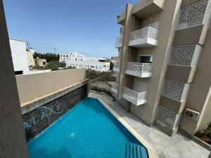 un edificio con piscina en frente de un edificio en Luxury apartment 3, en Hammamet