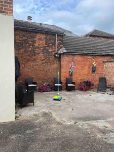 a patio with chairs and a pole in front of a brick building at Large 4 bedroom house in Heckington