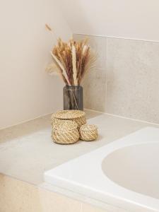 eine Vase mit einer Pflanze auf einer Badezimmertheke in der Unterkunft IndigoBoathouse - Luxury Duplex Nieuwpoort Jachthaven in Nieuwpoort + 18 Fotos