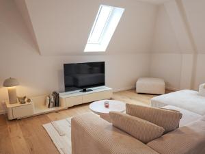 ein Wohnzimmer mit Couch und Flachbildfernseher in der Unterkunft IndigoBoathouse - Luxury Duplex Nieuwpoort Jachthaven in Nieuwpoort