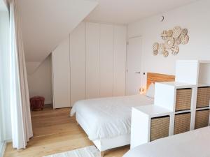 ein weißes Schlafzimmer mit zwei Betten und einem weißen Schrank in der Unterkunft IndigoBoathouse - Luxury Duplex Nieuwpoort Jachthaven in Nieuwpoort