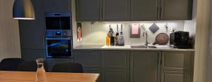 cocina con armarios grises y mesa de madera en Lakeside apartment, en Stryn