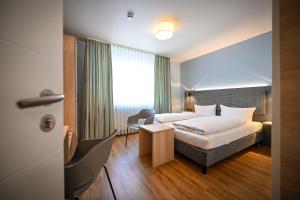 A bed or beds in a room at Hotel Mainblick Garni
