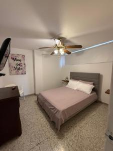 een slaapkamer met een bed en een plafondventilator bij Barrio El Golf Apartment in Barranquilla