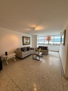 een woonkamer met twee banken en een tafel bij Barrio El Golf Apartment in Barranquilla