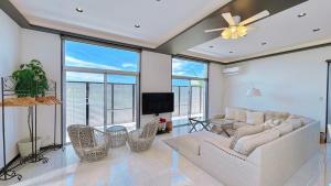 a living room with a couch and chairs and a tv at Palm Tree House Ishigaki - パームツリーハウス石垣 in Ishigaki Island