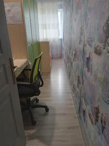 a room with a desk and a chair and a wall at Baku Confor Home in Baku