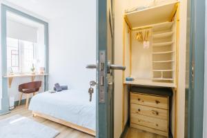 Un dormitorio pequeño con una cama y una cómoda. en Casa dos Loiros, en Figueira da Foz