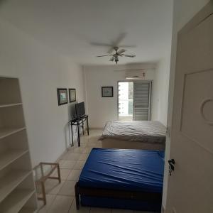 a bedroom with a bed and a ceiling fan at Guaruja ap lindo 200 m da praia in Guarujá
