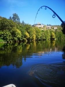 Montbrunにあるtente de trappeur au camping les cournoulises 2 à 4 personnesの釣り竿を持ったボートから見た川の景色