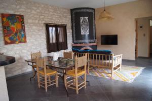 a dining room with a table and chairs and a fireplace at Villa Labri de la Plage 350 m from Beach & Center in Sidi Kaouki