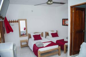 a bedroom with two beds and a mirror at Hotel Majestic plaza in Mompós +20 photos
