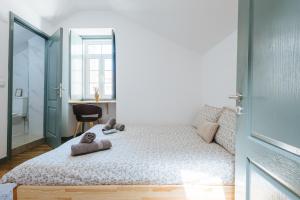 Un dormitorio con una cama con dos ositos de peluche encima. en Casa dos Loiros, en Figueira da Foz 3 fotos más