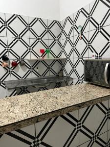 a kitchen with a counter and a tile wall at Casa simples e conforto in Belém +2 photos
