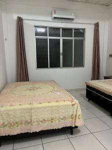a bedroom with a bed and a window with a air conditioner at Casa simples e conforto in Belém