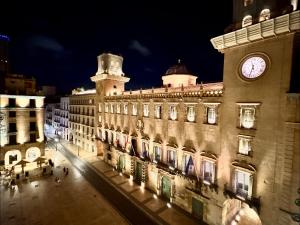 a large building with a clock tower on top of it at White Coast Suites in Alicante +10 photos