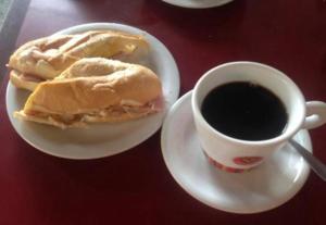 a sandwich on a plate next to a cup of coffee at Casa simples e conforto in Belém +2 photos
