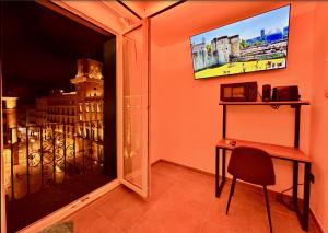 a room with a window with a desk and a television at White Coast Suites in Alicante