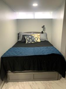 een slaapkamer met een groot bed met een blauwe deken bij A Cozy Corner with kitchen and parking in Drexel Hill