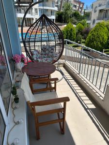 a balcony with a chair and a bird cage at Apartament Sunset Kosharitsa - Slunchev briag in Kosharitsa