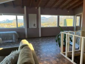 a living room with a couch and some windows at Hostería Las Rosas Trevelin in Trevelín