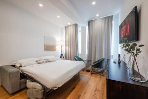 a bedroom with a bed and a desk in a room at Duomo Area Luxury Design & Netflix Mood in Milan