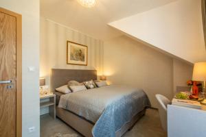 1 dormitorio con 1 cama y escritorio con lámpara en VILA DOMOVINA, en Tatranská Lomnica