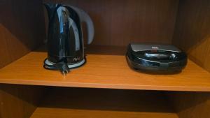a black appliance sitting on a wooden shelf at Eleni Golden - Comfort Stay 2 in Loutra Oraias Elenis 