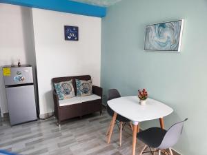 a kitchen with a table and a chair and a refrigerator at EcoApartamentos Sunset Life in Providencia